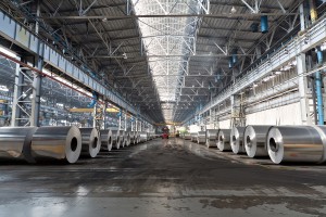 Rows of rolls of aluminum lie in production shop of plant.