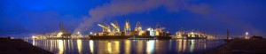A panoramic image of  three container ships being unloaded at ni