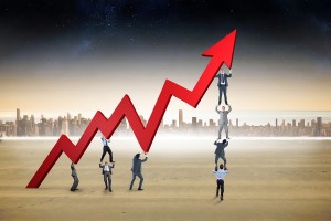 Business team holding up arrow against cityscape on the horizon