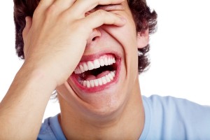Close up portrait of hard laughing young man. Isolated on white