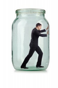 Young businessman in glass jar